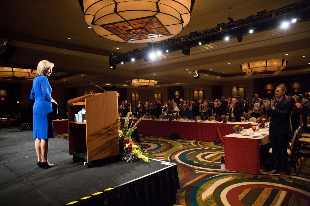 A woman receives a standing ovation after a speech