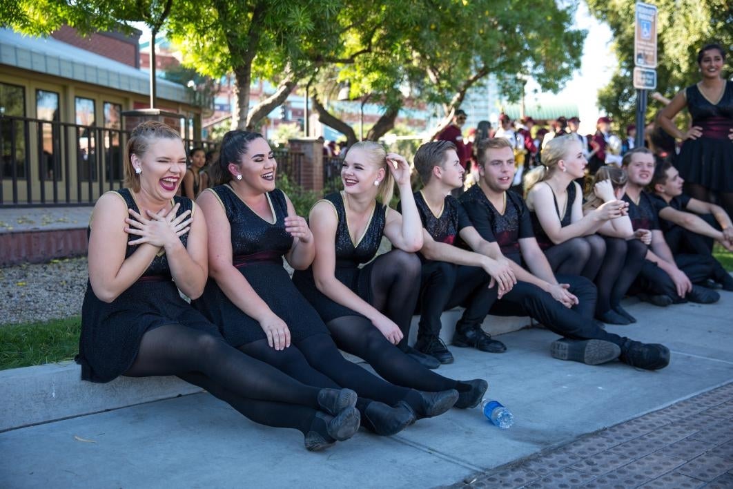 dancers sitting on sidewalk