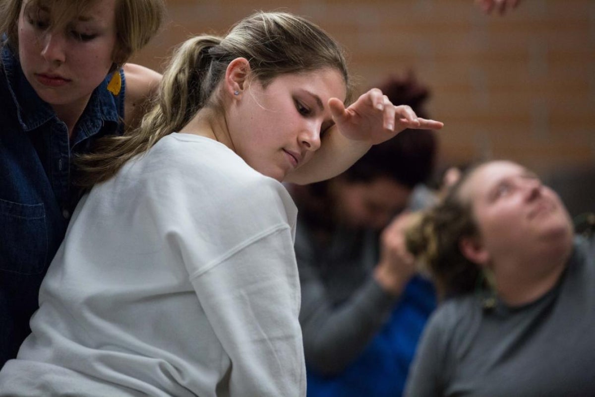 dancers rest their heads on one another