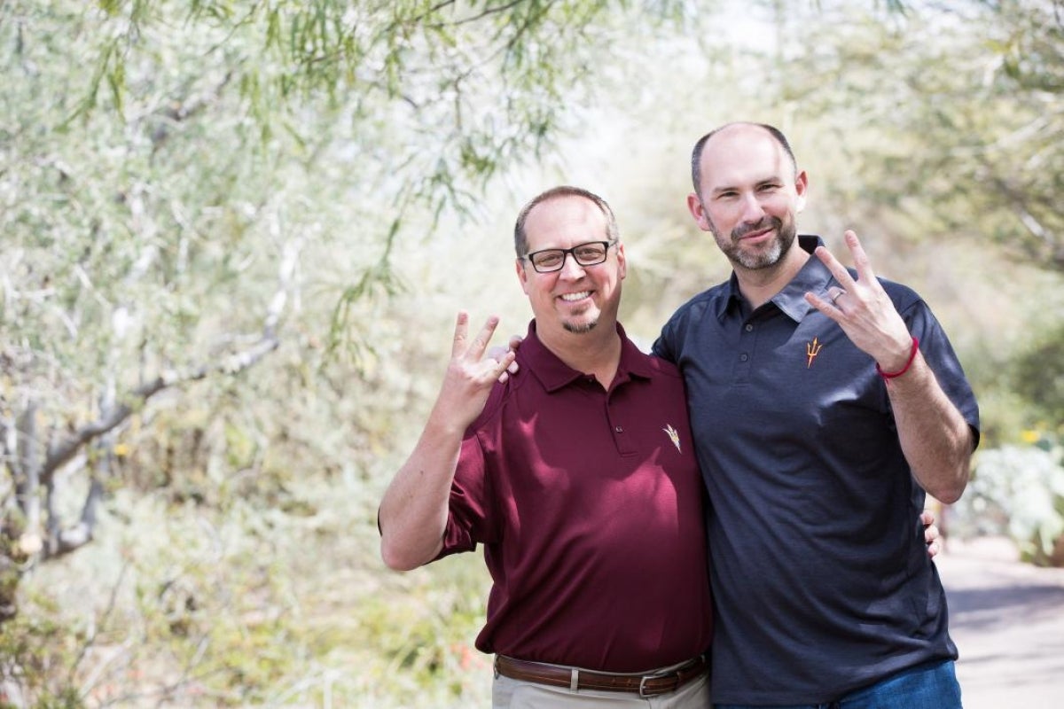 two men flashing the Sun Devil pitchfork sign