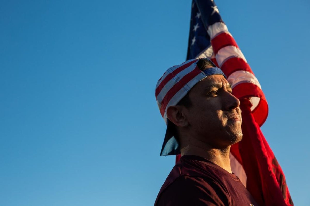 man standing next to flag