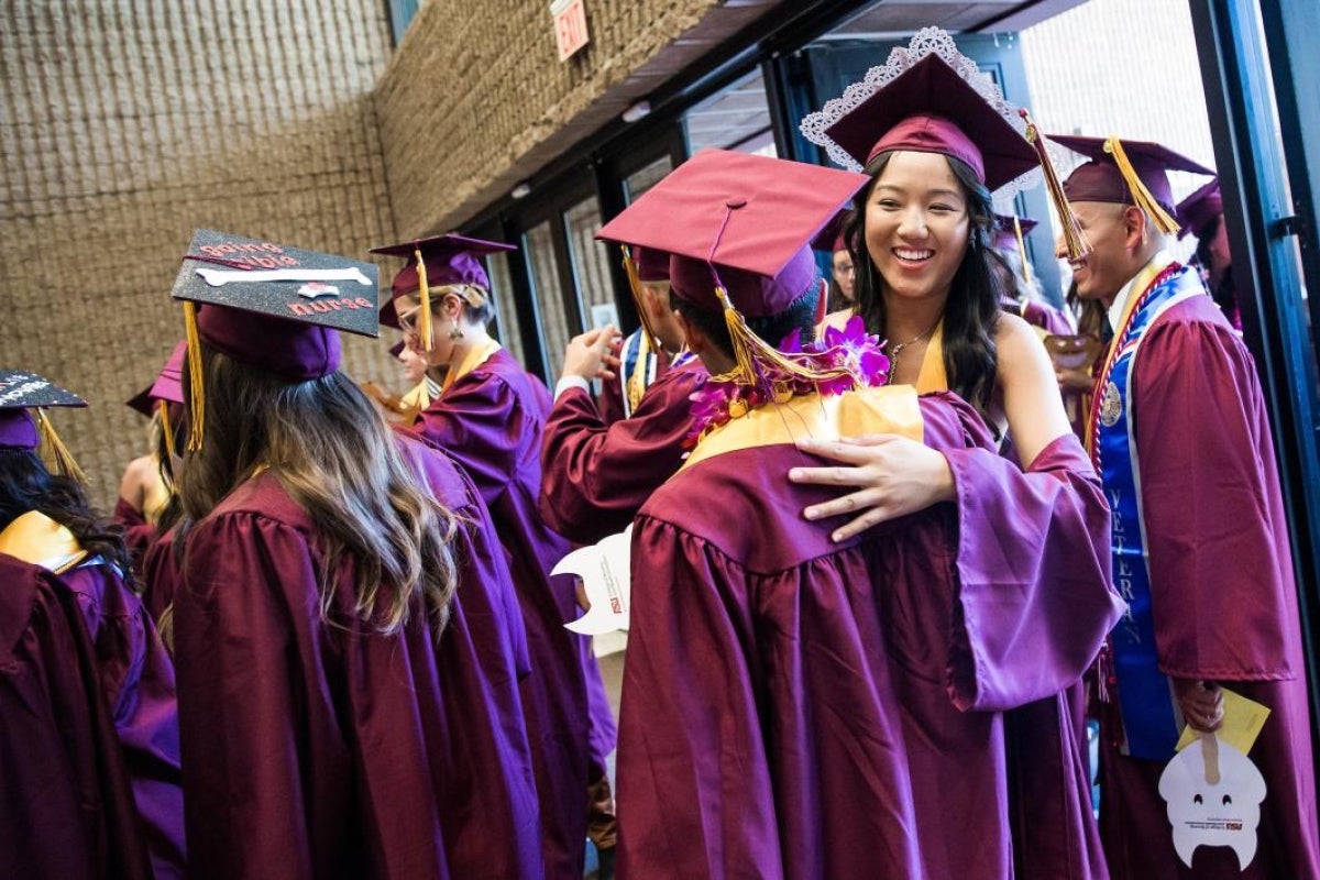 graduate hugging friend