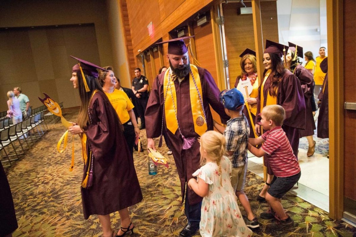 graduate high-fiving his children