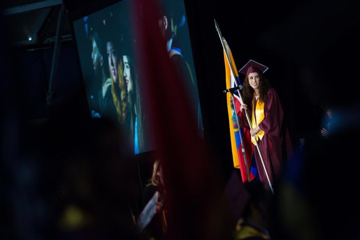 woman holding flag at graduation ceremony