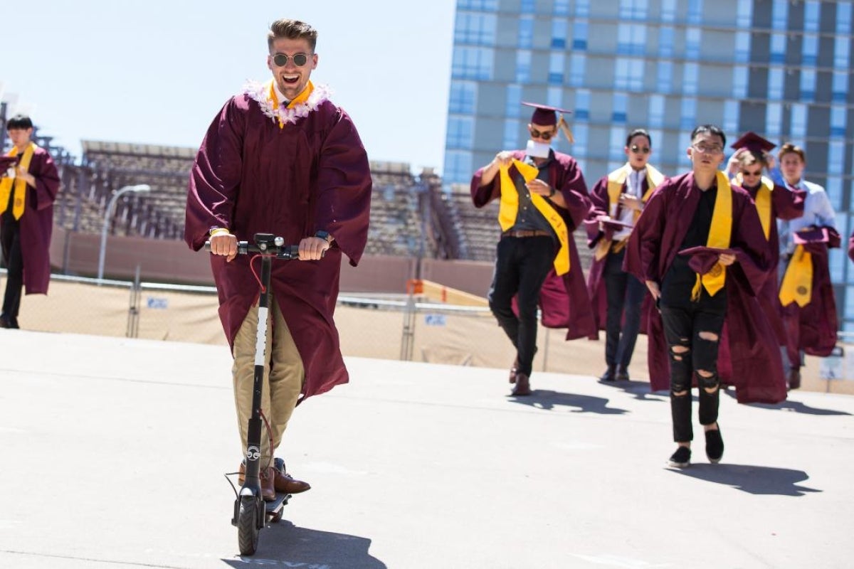 graduate riding scooter