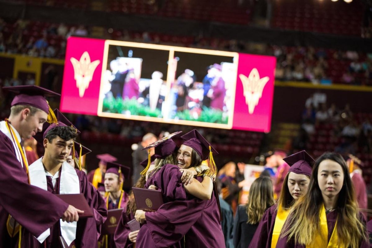 two grads hugging