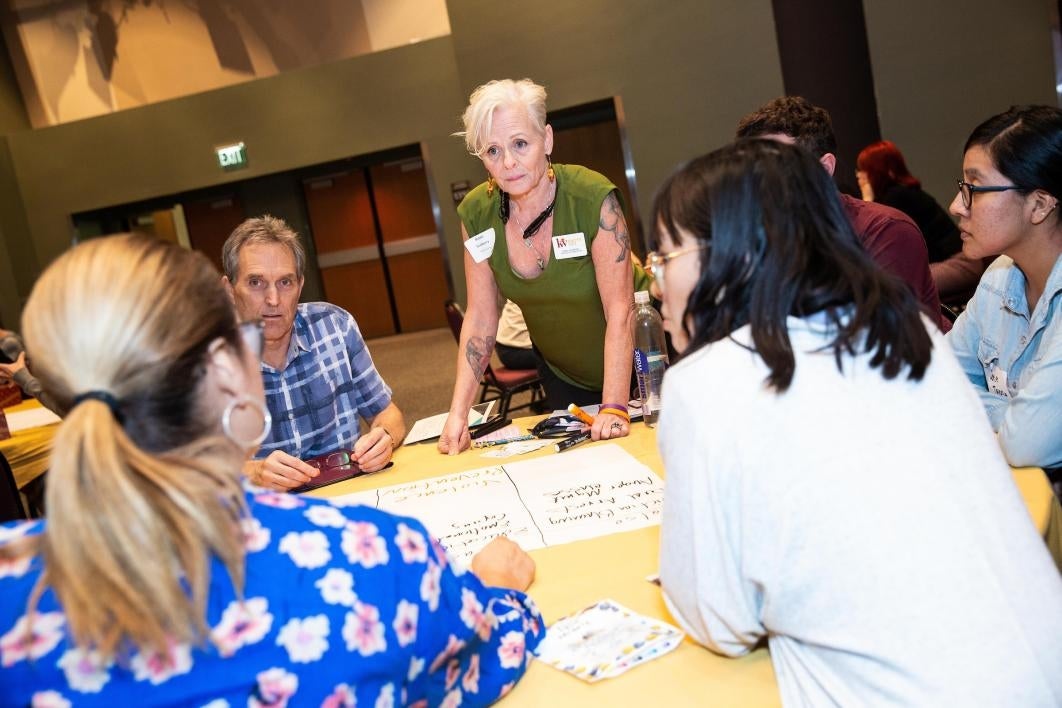 Participants at a conference on preventing domestic violence write ideas on a poster