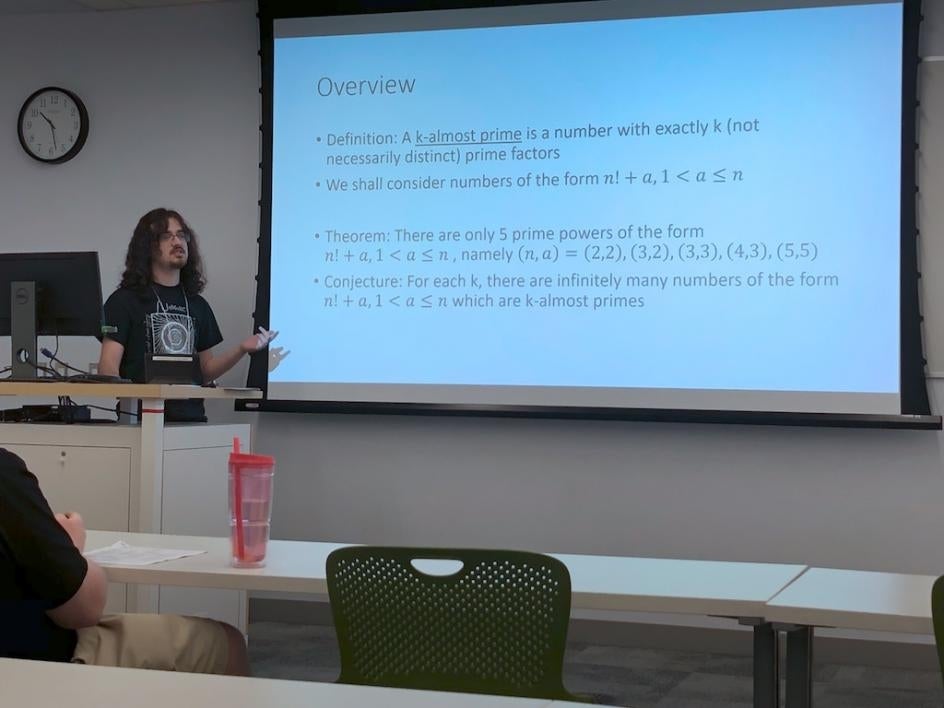 Liam Lawson presented a research talk titled Almost-Primes Near Factorials