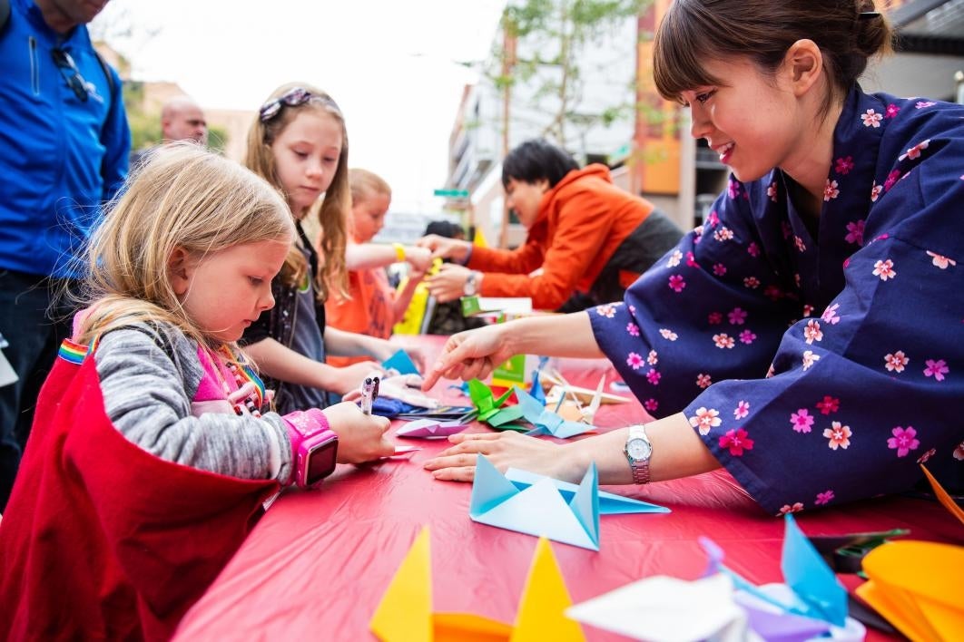 young girl makes origami