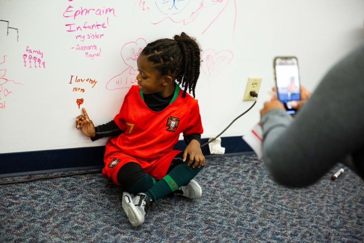 girl smiles in front of whiteboard