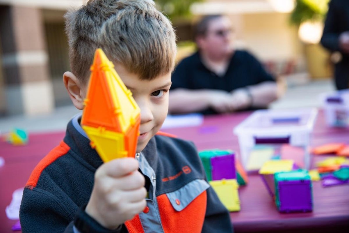 boy holds geometric blocks