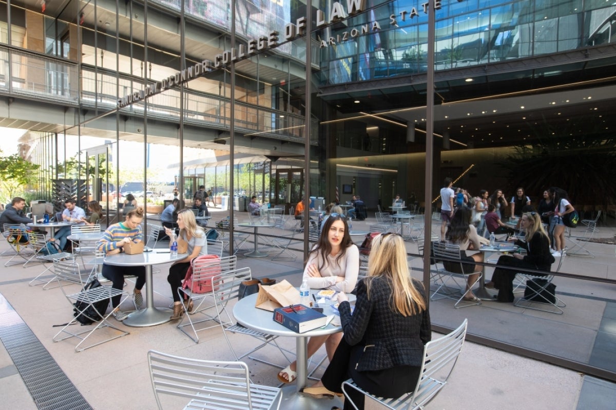 Students sitting at tables outside of the ASU Law building in Phoenix