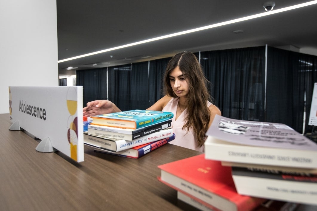 student shelving books at library