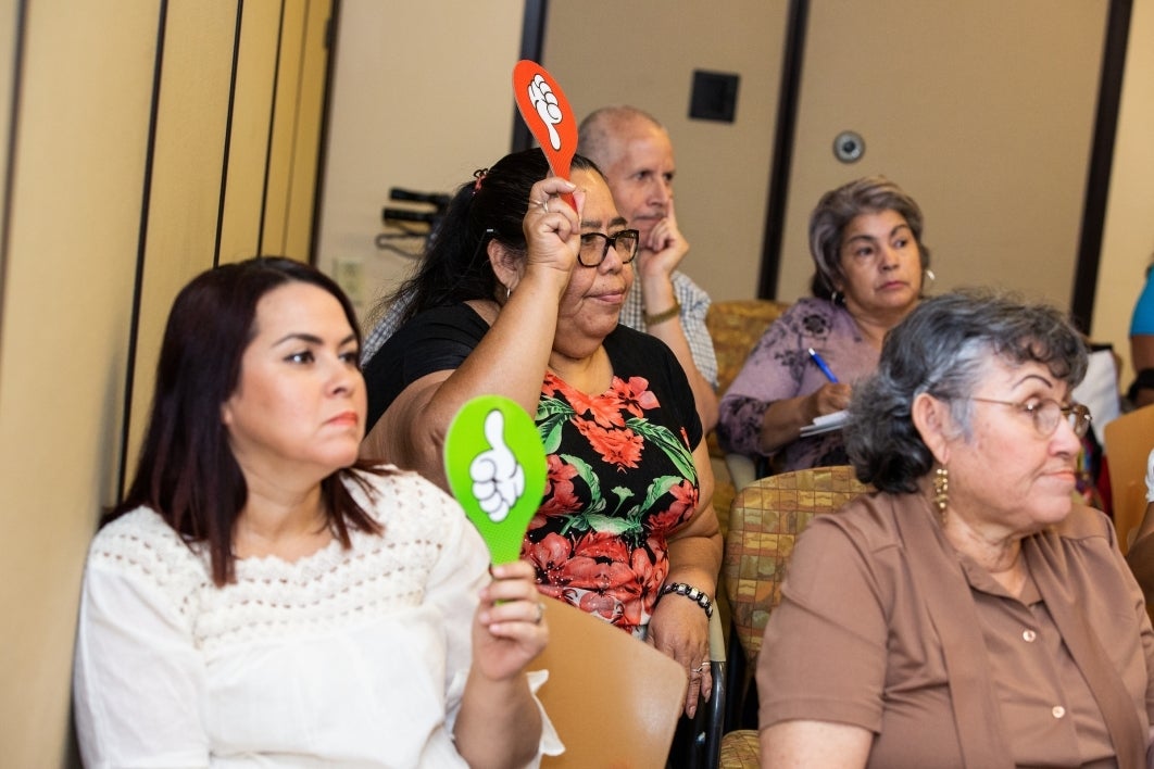 women holding up red and green paddles