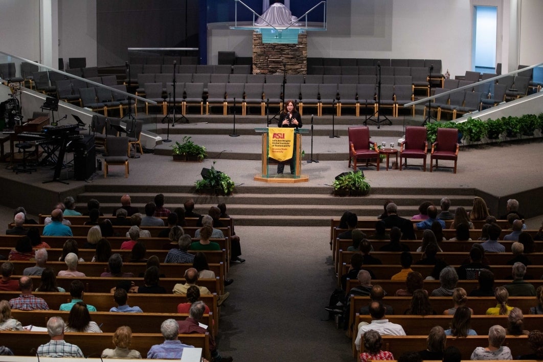 Climate scientist Katharine Hayhoe speaks from the front of a church