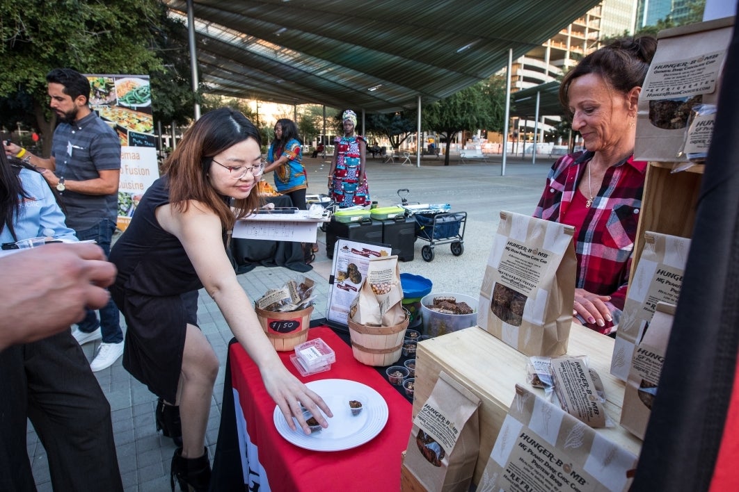 Judge Cindy Louie, with Haker Street Market, tries a sample Hunger-Bomb cookie from owner Tanya Batche