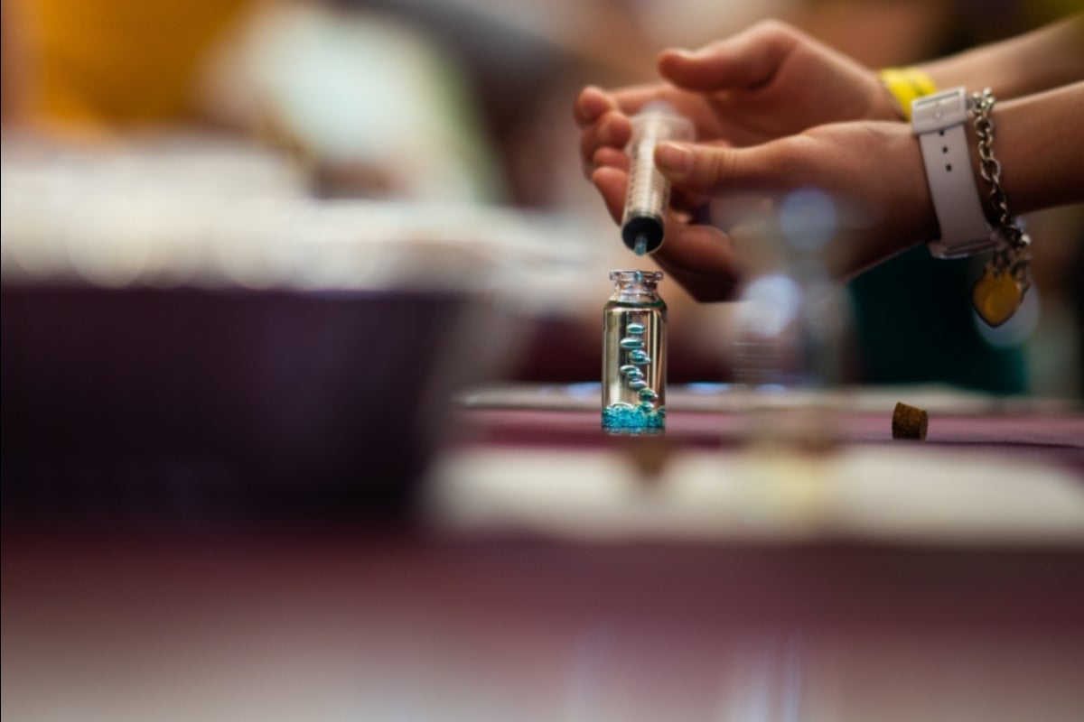 a syringe is used with a glass bottle to create a 'lava lamp' effect in oil