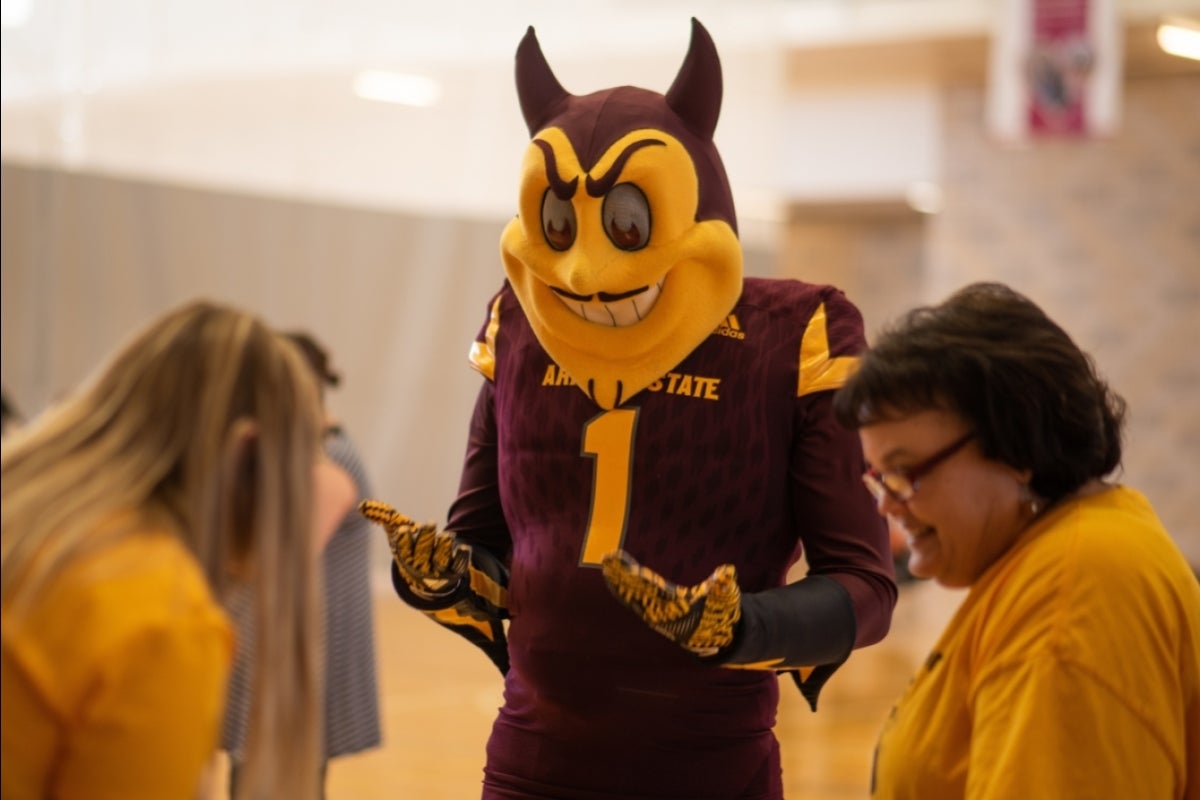 asu mascot sparky greets a family at asu west