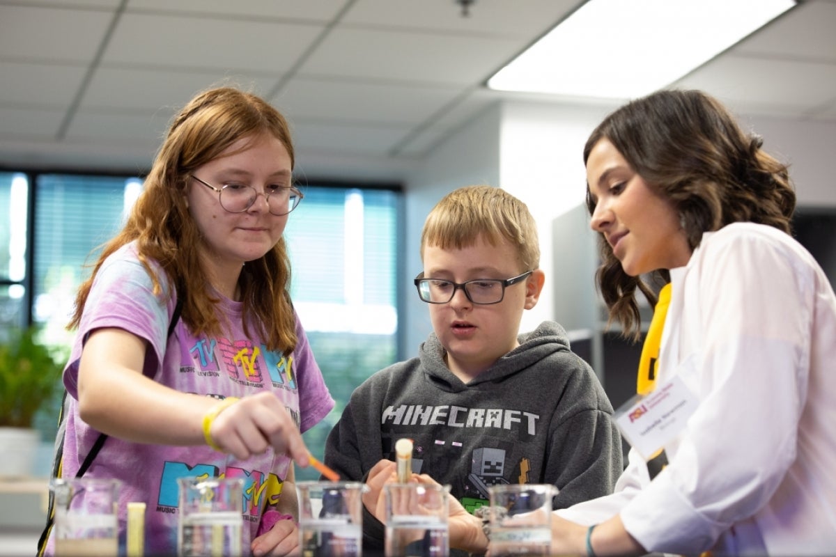 teenage girl and boy learn about ph from a scientist