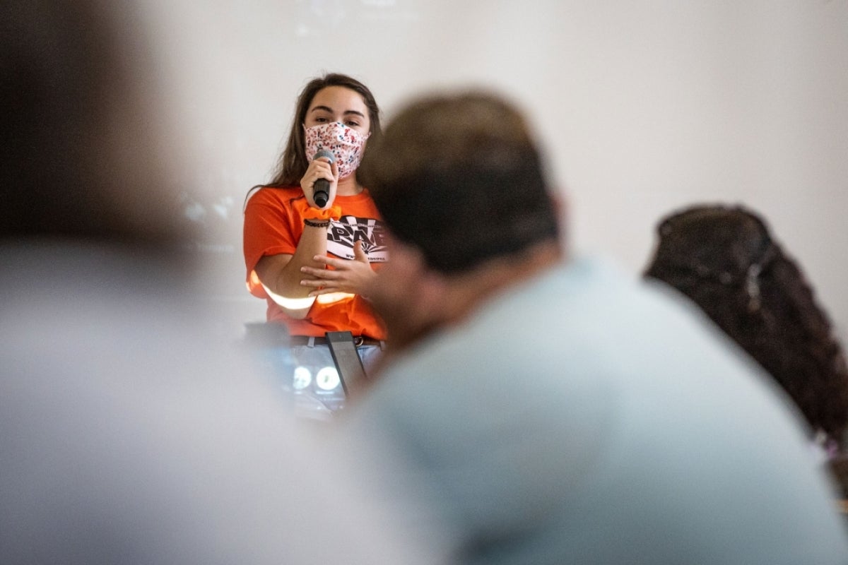 student talks to group