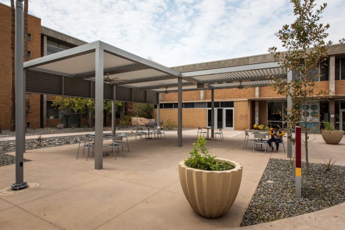 A shade structure with tables and ceiling fans