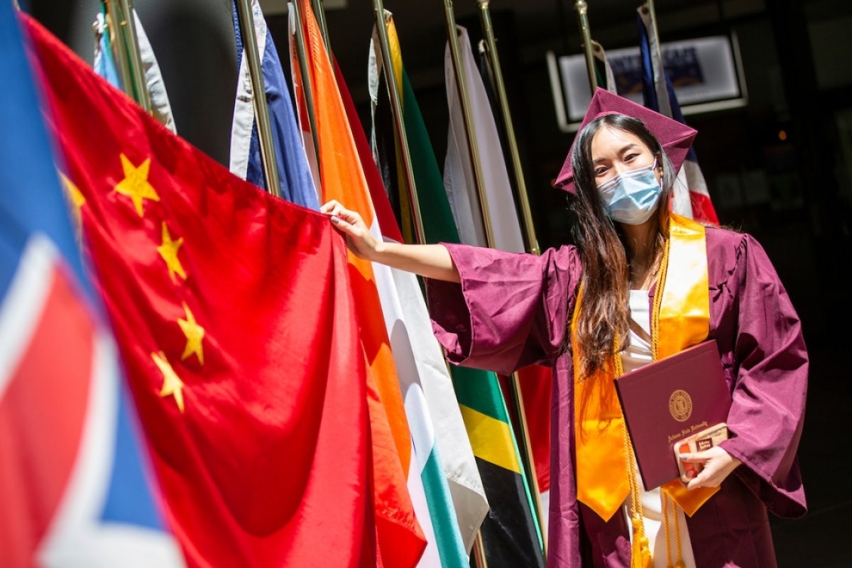 Xi Ling holds up her country's flag at Thunderbird ceremony