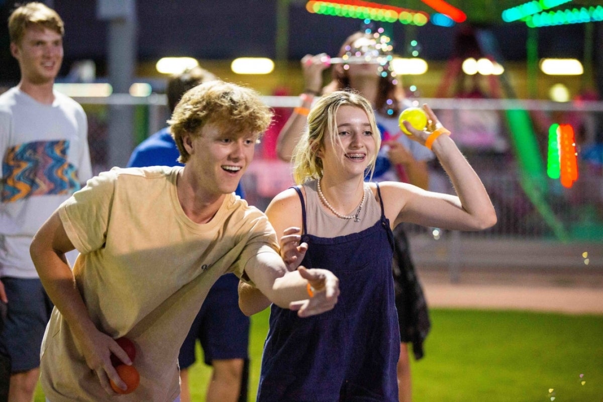 Students throw balls in a skeeball game