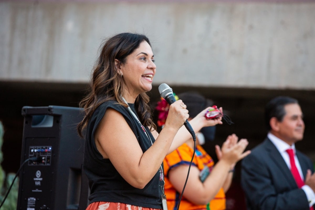 A woman speaks at a microphone