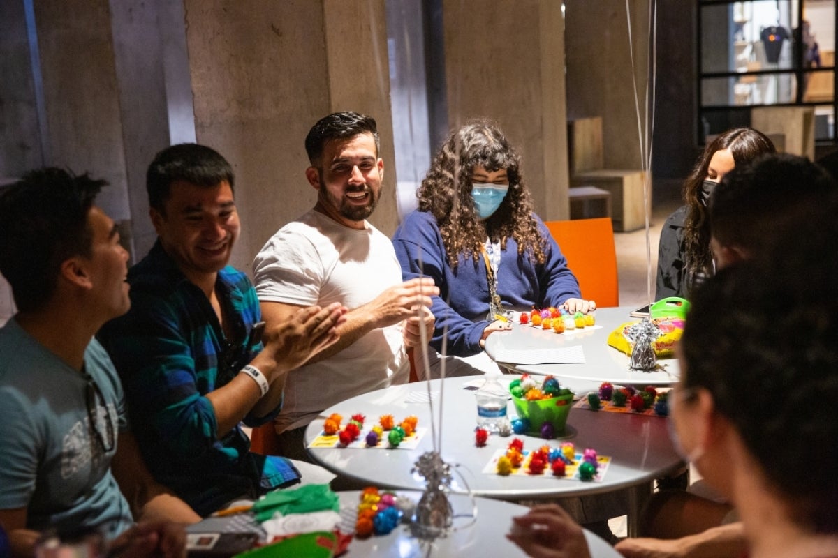 People sitting around tables play loteria