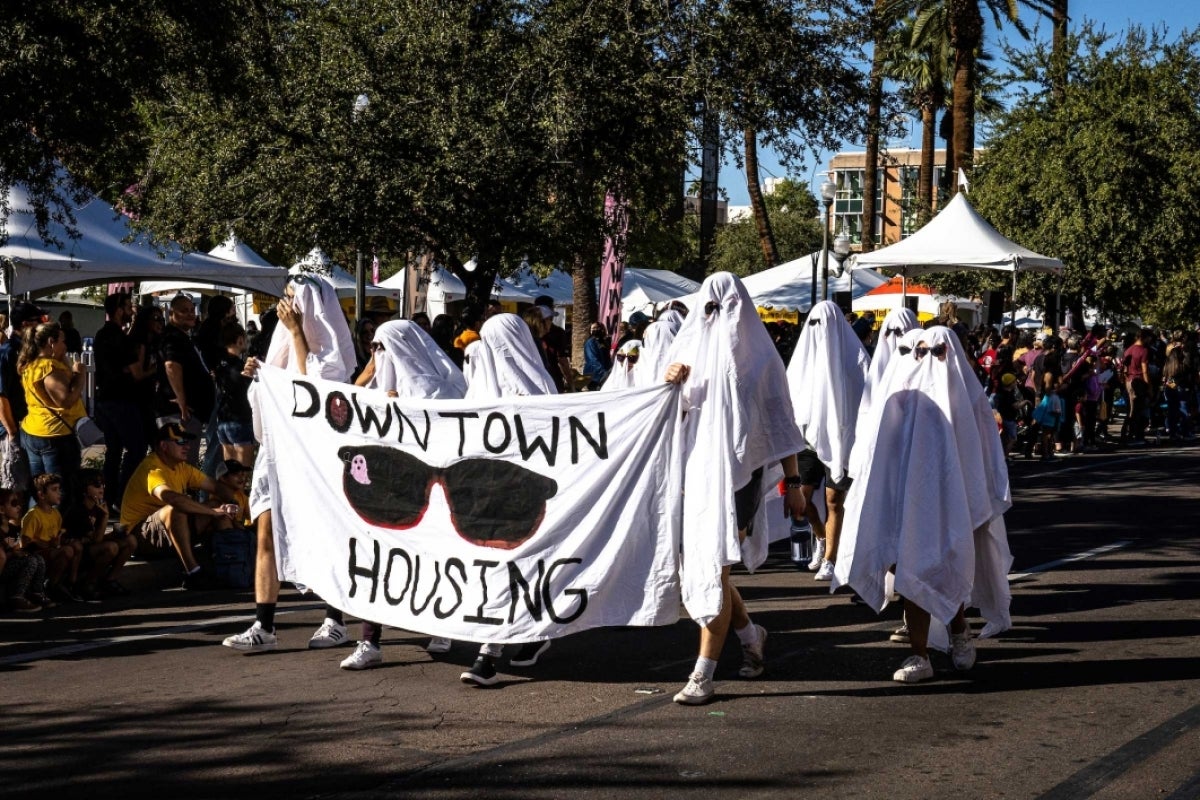 Students representing downtown housing are dressed as ghosts for the Homecoming parade