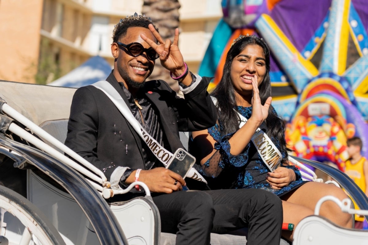 The ASU Homecoming king and queen wave from their carriage during the Homecoming parade