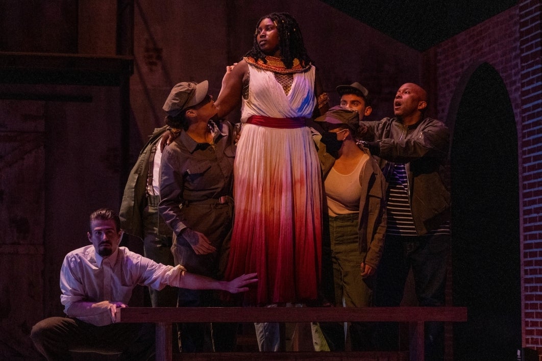 People surrounding a woman during the dress rehearsal for 