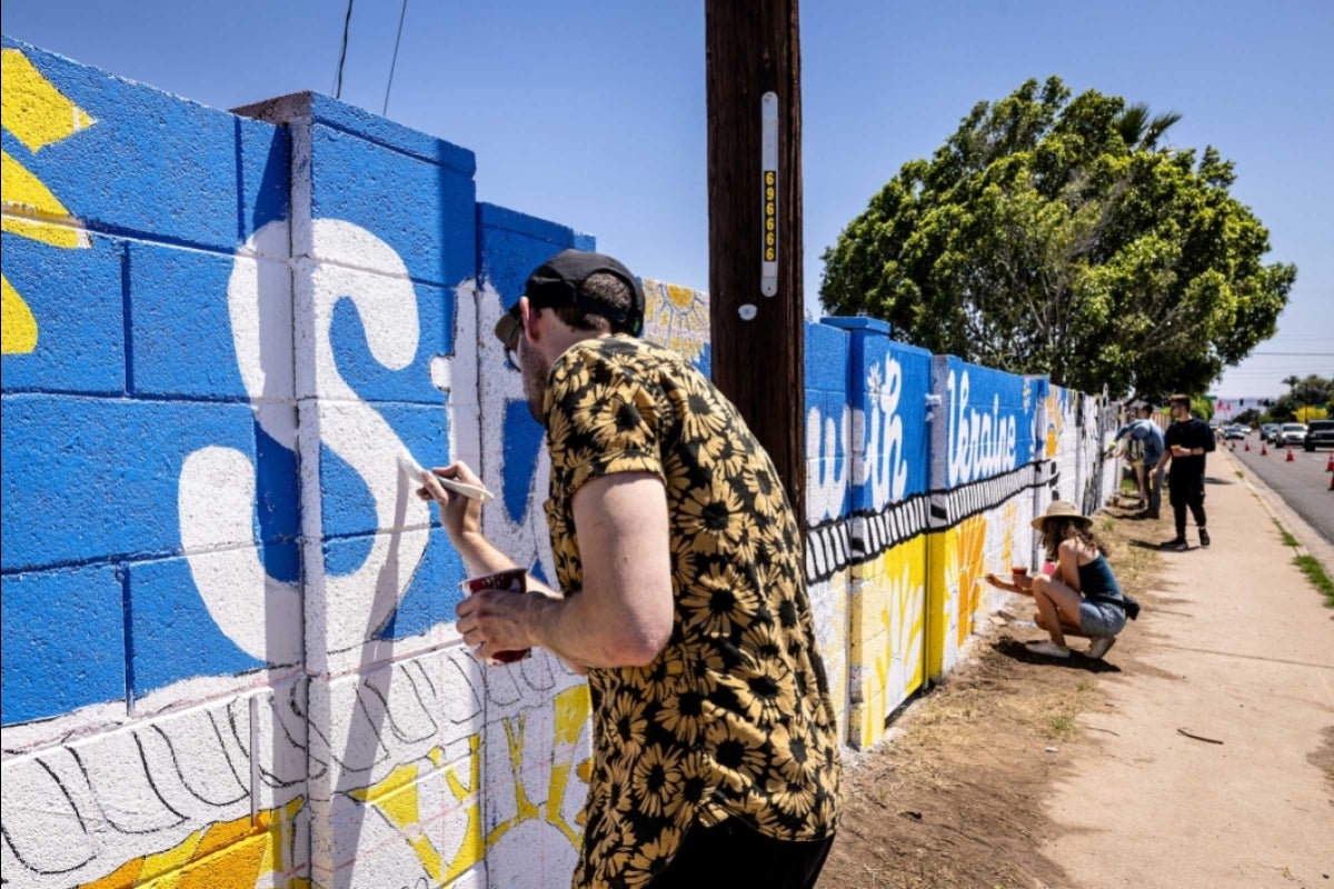 Student painting a wall mural