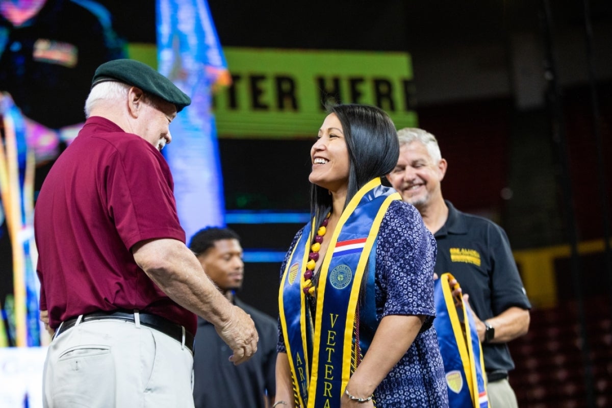 A woman smiles broadly as she receives her veterans stole