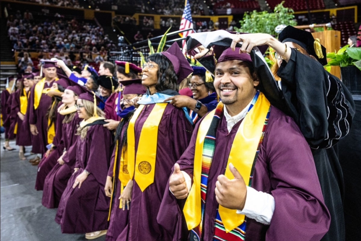 Line of graduates receiving their doctoral hoods