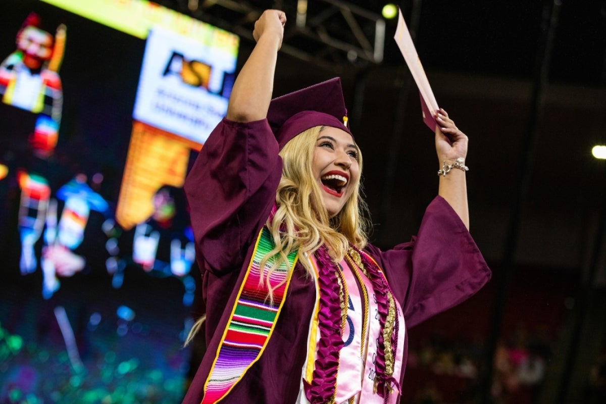 Female graduate cheering on stage during convocation