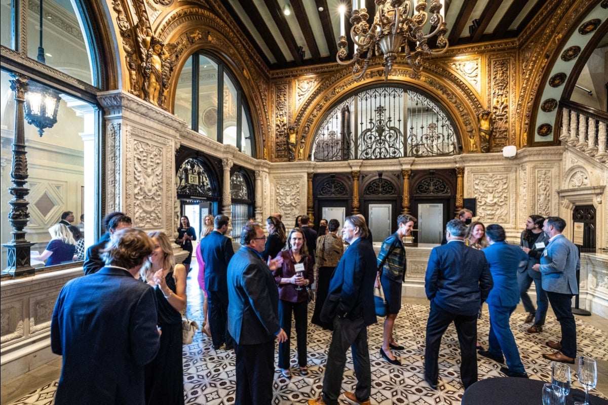 A crowd of people mingle in the ornate lobby of the Herald Examiner building in LA