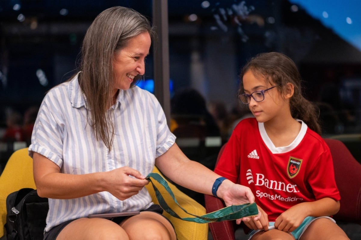 Mother and child looking at an Olympic gold medal