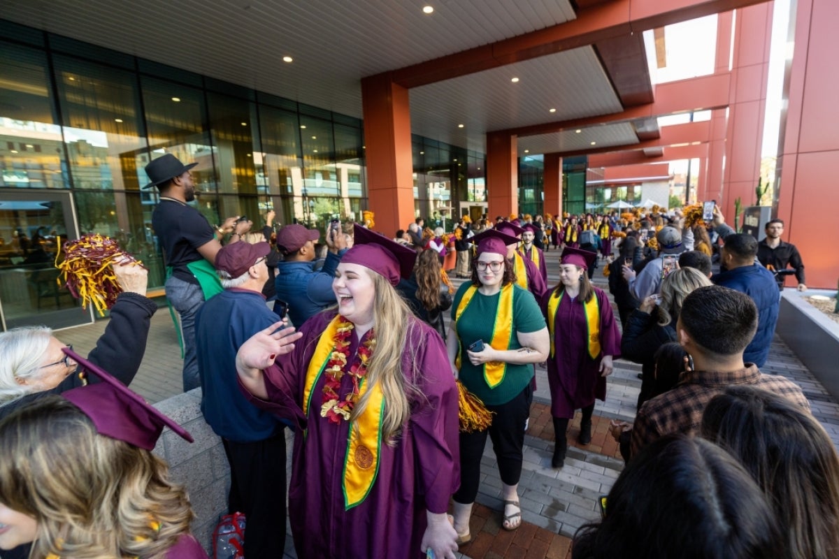 Group of graduates walking down sidewalk