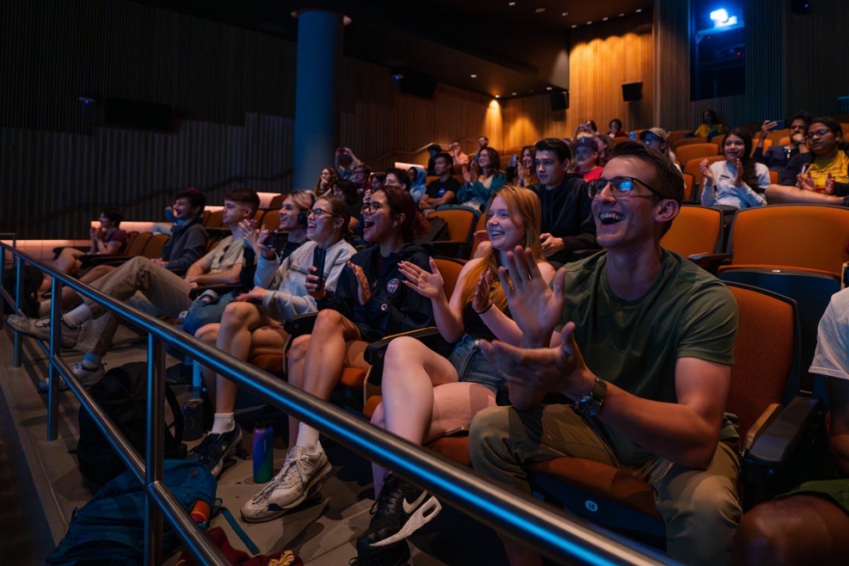 Students in an audience cheer for liftoff