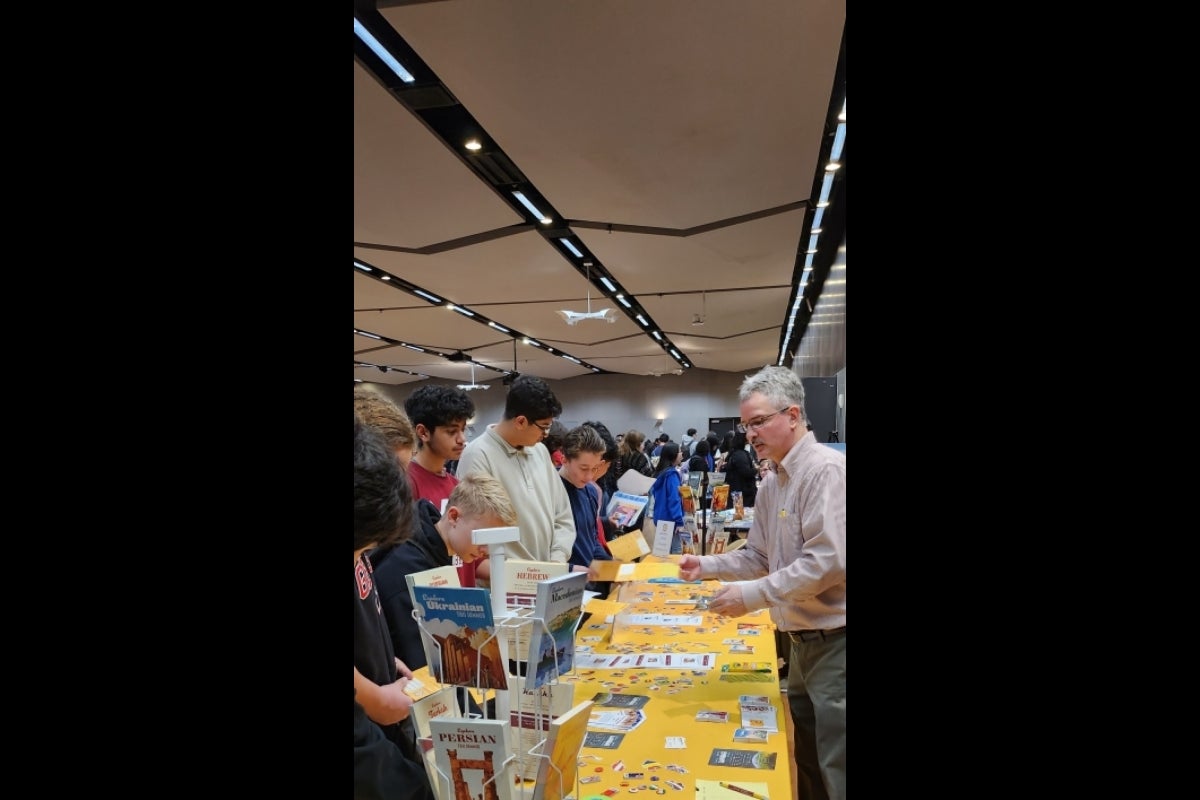 Several high school students browsing the Critical Language Institute's table