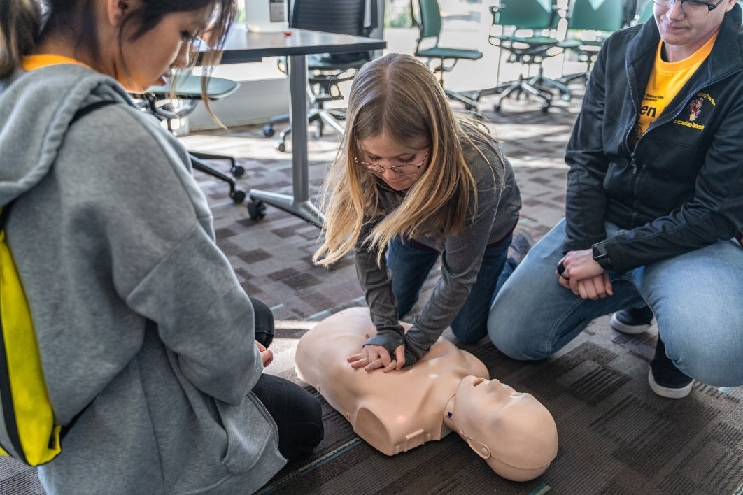 Woman practices CPR on a manikin