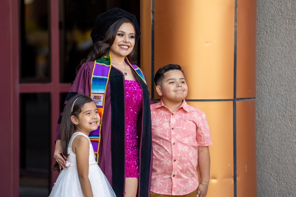 Graduate posing with two children