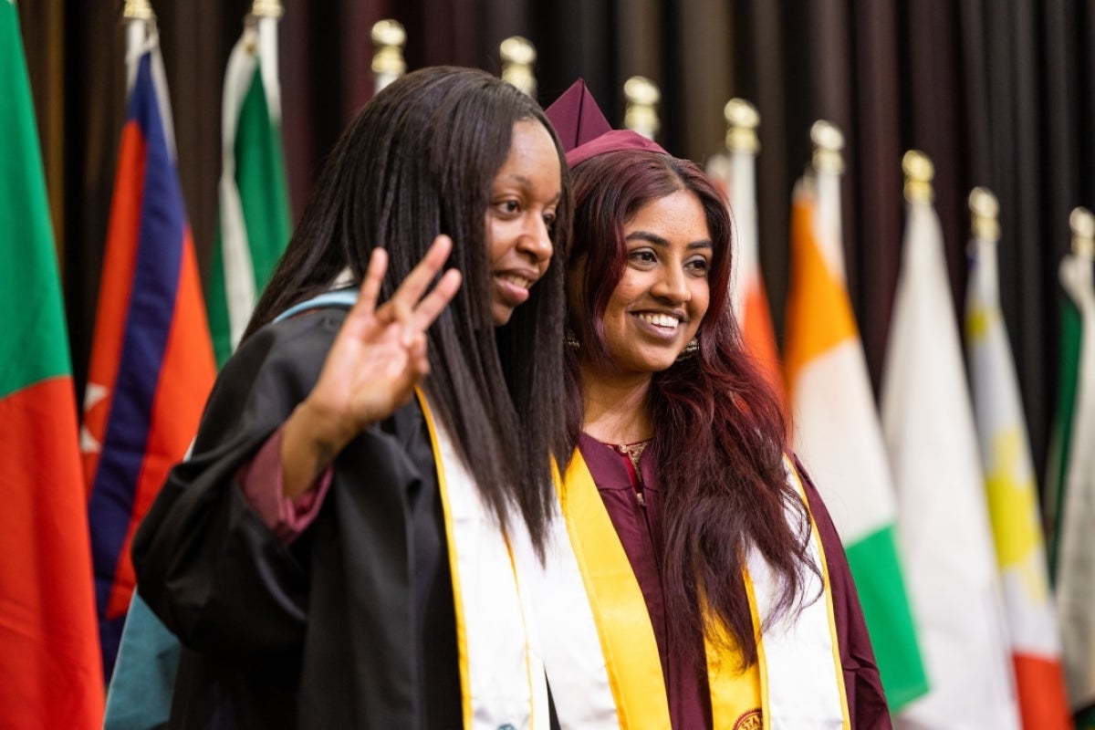 Graduate posing with dean at convocation