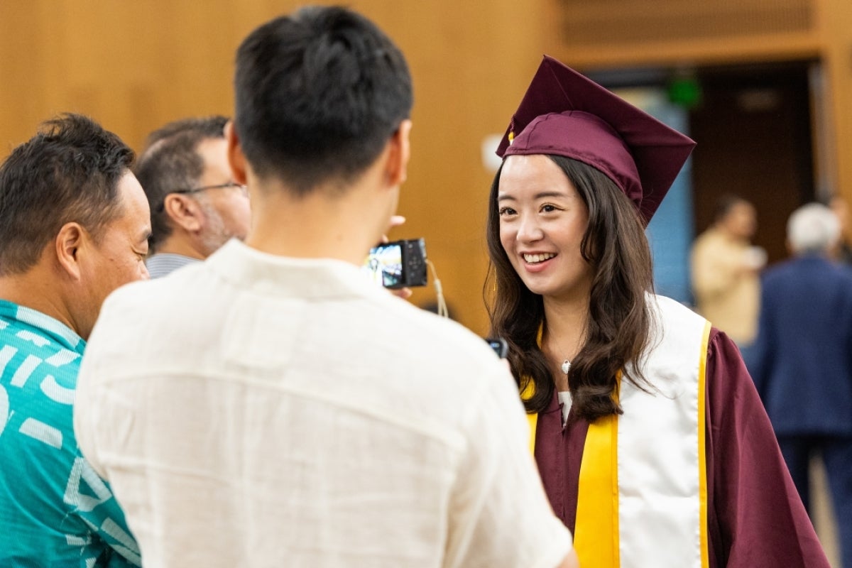 Woman posing for photo for her family at convocation