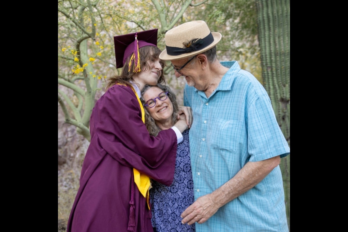 Parents hug their graduate