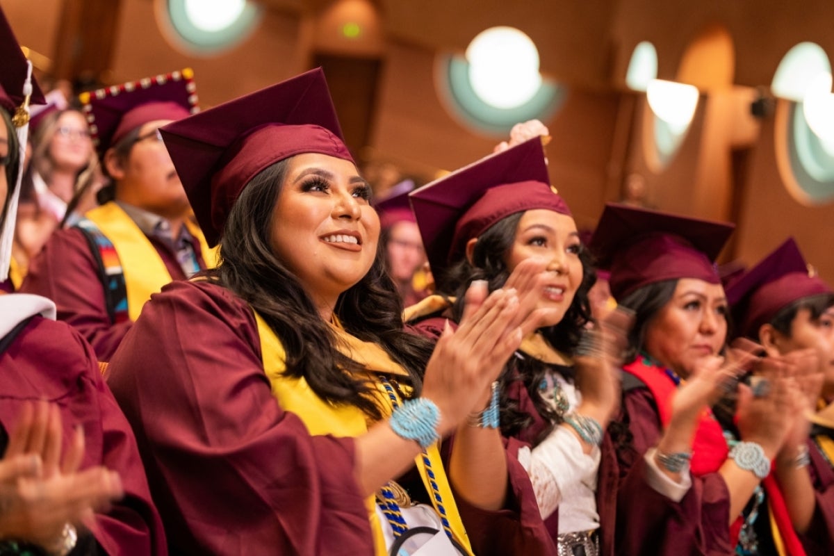 Graduates clap during convocation at ASU Gammage