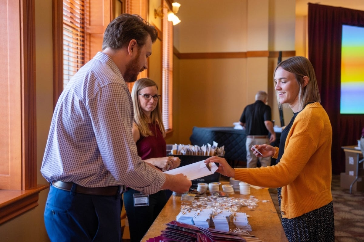 People packing envelopes with ASU promotional material.