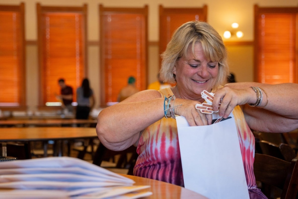 Woman putting stickers into an envelope.