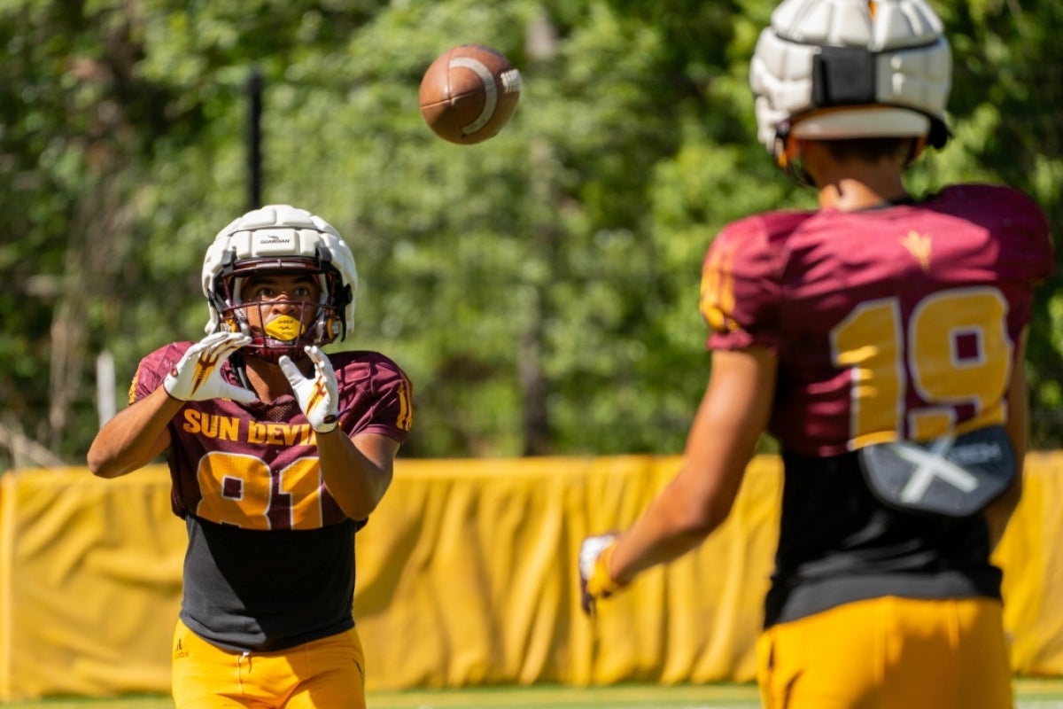 A football player throws a ball to another player